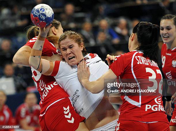 Denmark's Mette Bjorholm Gravholt challenges Poland's Alina Wojtas and Karolina Szwed during the 2013 Women's Handball World Championship match for...