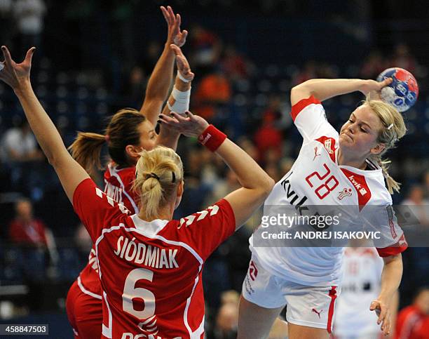 Poland's Iwona Niedzwiedz and Karolina Siodmiak challenge Denmark's Stine Jorgensen during the 2013 Women's Handball World Championship match for...