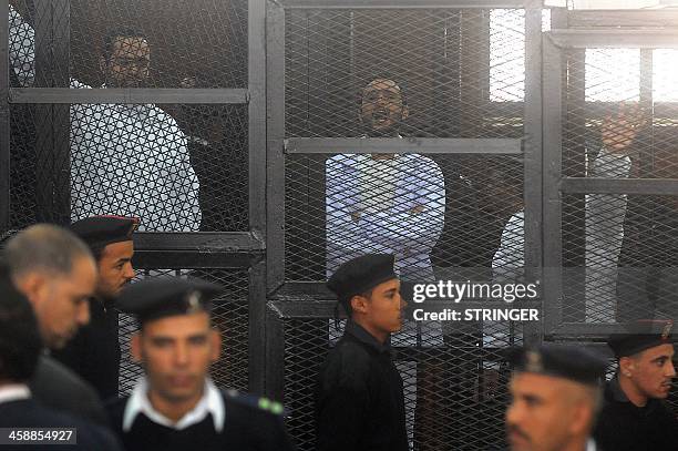 Egyptian activicts Mohamed Adel , Ahmed Douma and Ahmed Maher stand in the accused dock during their trial on December 22, 2013 in the capital Cairo....