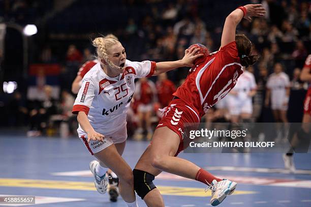 Denmarks Trine Ostergaard Jensen vies with Polands Karolina Kudlacz during the Women's Handball World Championship match for third place between...