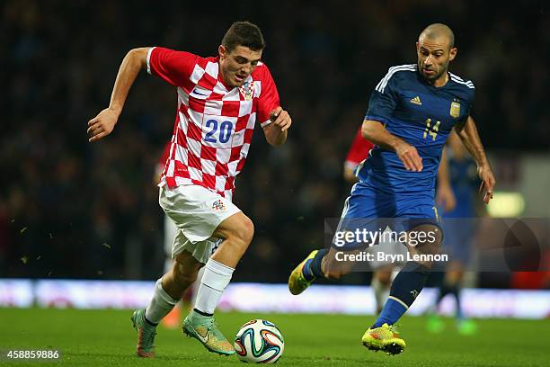 Mateo Kovacic of Croatia avoids Javier Mascherano of Argentina during the International Friendly between Argentina and Croatia at Boleyn Ground on...