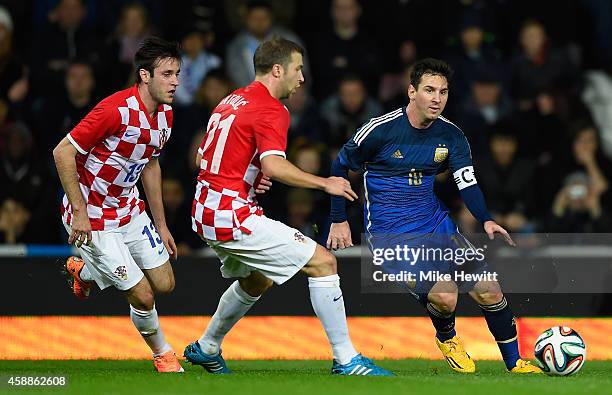 Lionel Messi of Argentina is challenged by Duje Cop and Domagoj Antolic of Croatia during an International Friendly between Argentina and Croatia at...