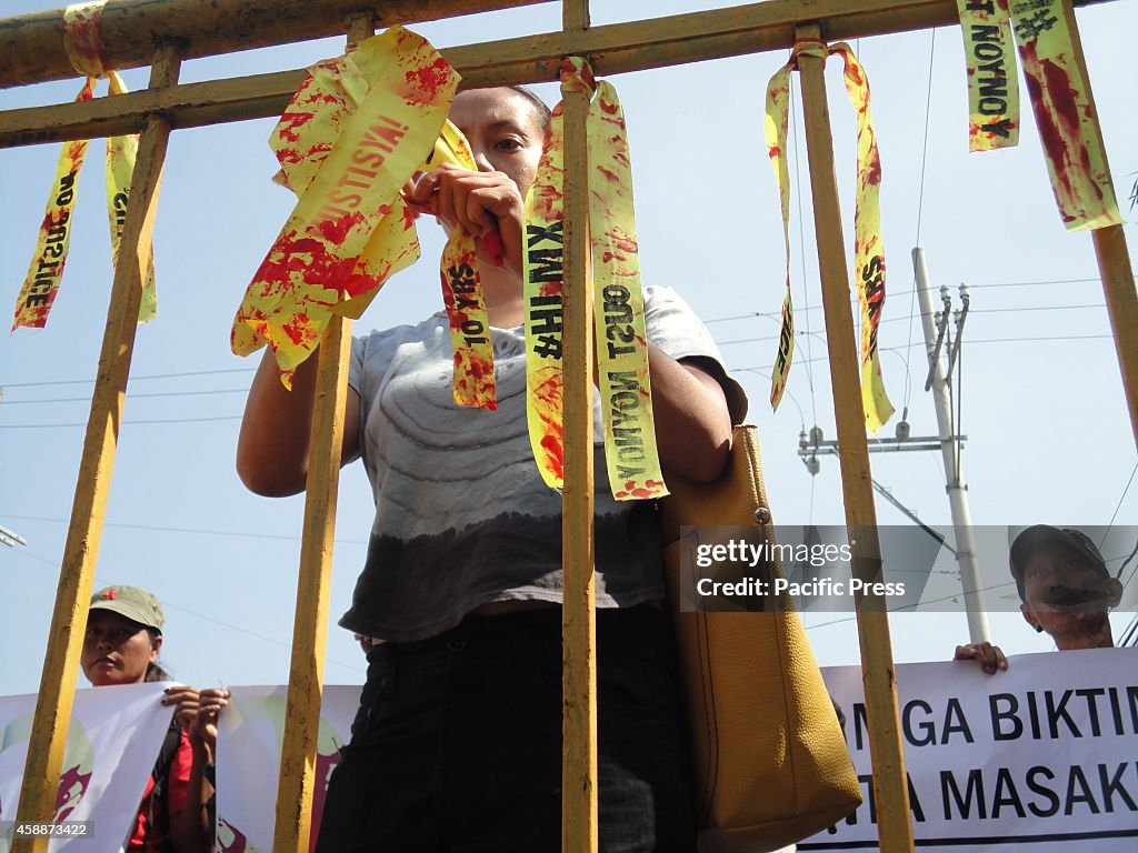 An activist ties a blood-stained ribbon on a barricade near...