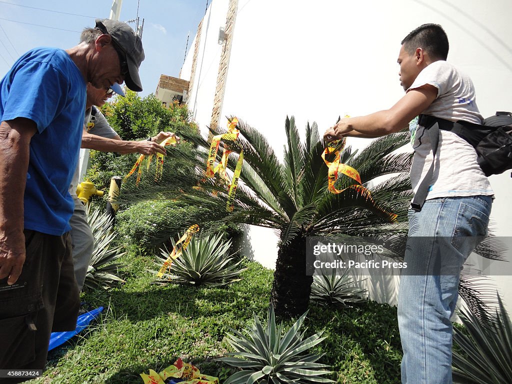 Activists place blood-stained ribbons on an Oliva plant in...