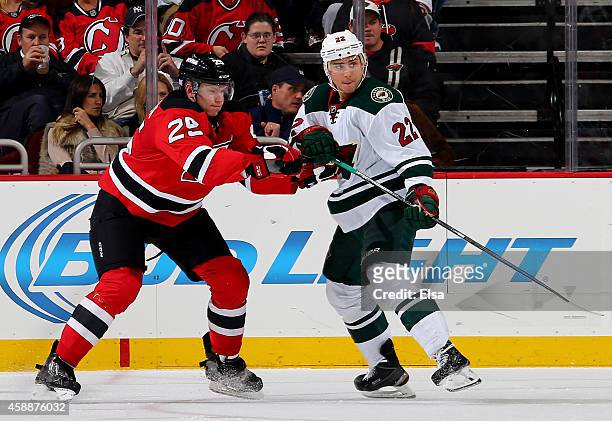 Seth Helgeson of the New Jersey Devils and Nino Niederreiter of the Minnesota Wild fight for position on November 11, 2014 at the Prudential Center...