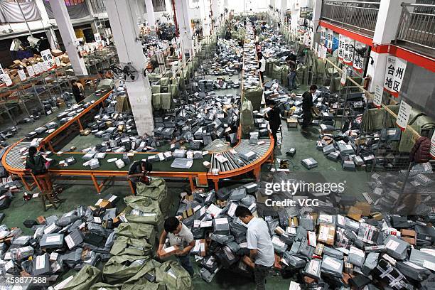 Express crew deal with express packages at assembly line on November 12, 2014 in Wenzhou, Zhejiang province of China. Online shopping websites...