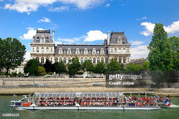 ausflugsboot übersät mit touristen auf dem fluss seine, paris, frankreich - rathaus von paris stock-fotos und bilder