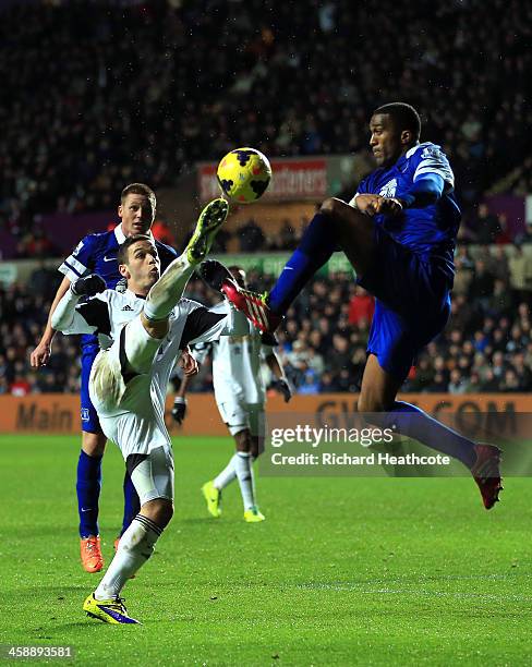 Alvaro Vazquez of Swansea and Sylvain Distin of Everton compete for the ball during the Barclays Premier League match between Swansea City and...