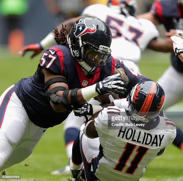 Justin Tuggle of the Houston Texans lays a hard hit on Trindon Holliday of the Denver Broncos on a punt return in the second quarter at Reliant...
