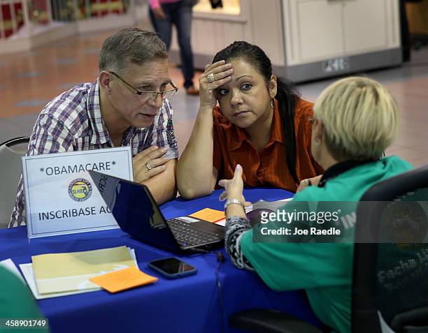 Angel Rivera and his wife Wilma Rivera sit with, Amada cantera, an insurance agent with Sunshine Life and Health Advisors as they try to purchase...