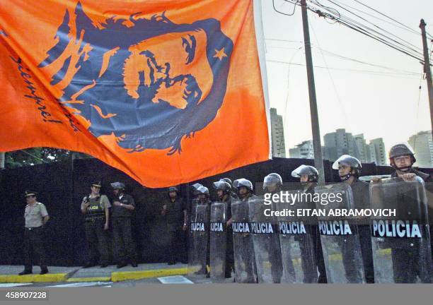 Riot police stand before a large banner bearing the image of leftist revolutionary Che Guevara as national leaders from Spain, Portugal and their...
