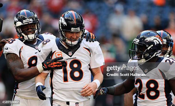 Peyton Manning of the Denver Broncos celebrates with Demaryius Thomas and Montee Ball after Manning set the NFL record for touchdown passes in a...