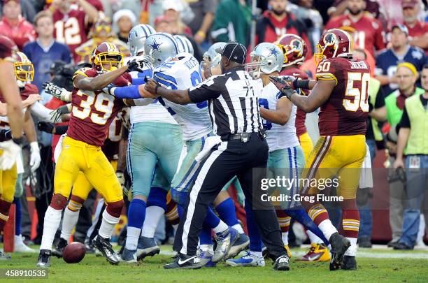 Officials try to break up an altercation in the fourth quarter between the Dallas Cowboys and the Washington Redskins at FedExField on December 22,...