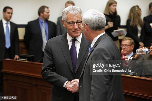 Defense Secretary Chuck Hagel greets members of Congress before testifying to the House Armed Services Committee about the ongoing fight against the...