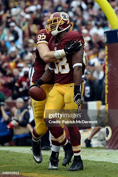 Pierre Garcon celebrates with Logan Paulsen of the Washington Redskins after scoring a touchdown in the third quarter during an NFL game against the...