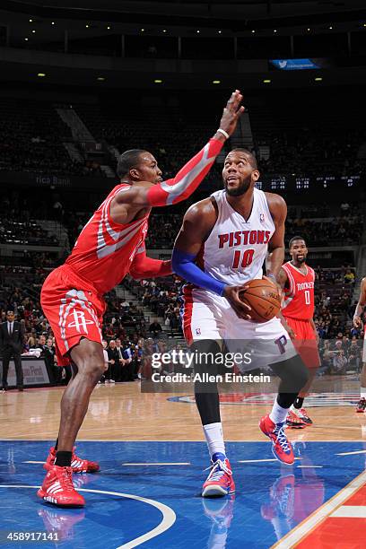 Greg Monroe of the Detroit Pistons attempts to shoot against Dwight Howard of the Houston Rockets on December 21, 2013 at The Palace of Auburn Hills...