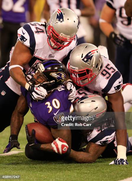 Running back Bernard Pierce of the Baltimore Ravens is tackled by Dont'a Hightower, Chandler Jones, and Brandon Spikes of the New England Patriots...