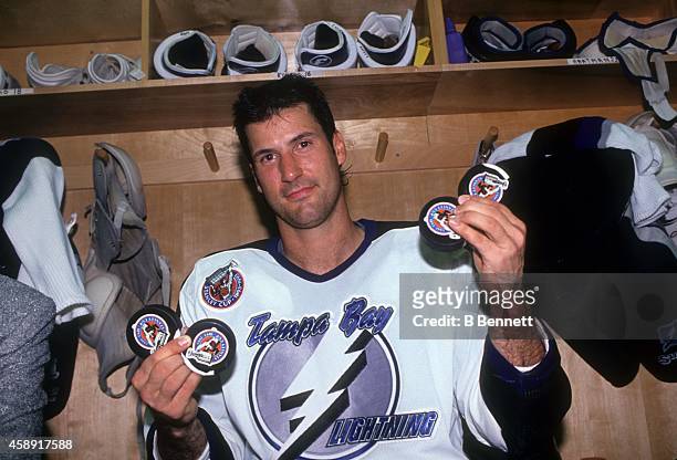 Chris Kontos of the Tampa Bay Lightning poses in the locker while holding up the four pucks in which he scored during the first game played by the...