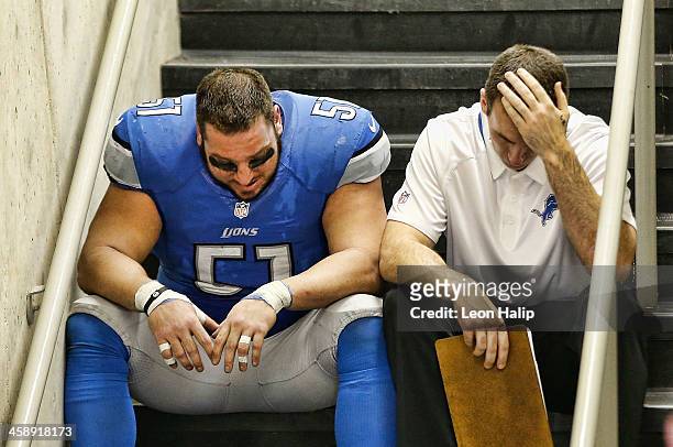 Dominic Raiola of the Detroit Lions sits on the steps with a coach after the Lions lost in over time to the New Yrok Giants at Ford Field on December...