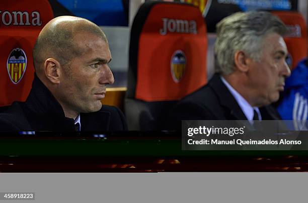 Head coach Carlo Ancelotti of Real Madrid looks on with assistant coach Zinedine Zidane during the start of the La Liga match between Valencia CF and...