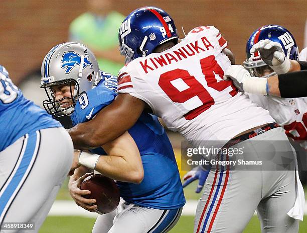 Matthew Stafford of the Detroit Lions is sacked in the fourth quarter by Mathias Kiwanuka of the New York Giants at Ford Field on December 22, 2013...