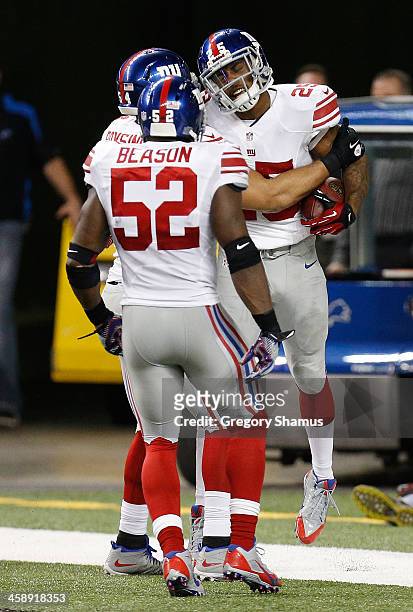 Will Hill of the New York Giants celebrates his fourth quarter interception for a touchdown with Jon Beason and Spencer Paysinger while playing the...