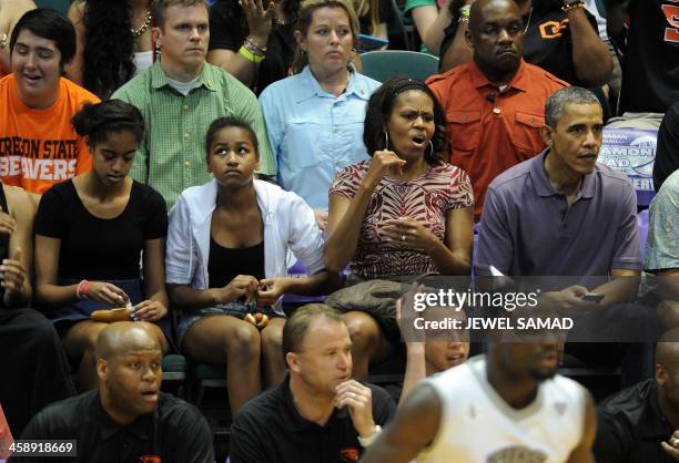 President Barack Obama, First Lady Michelle Obama and their daughters Malia and Sasha watch the Oregon State University vs University of Akron...