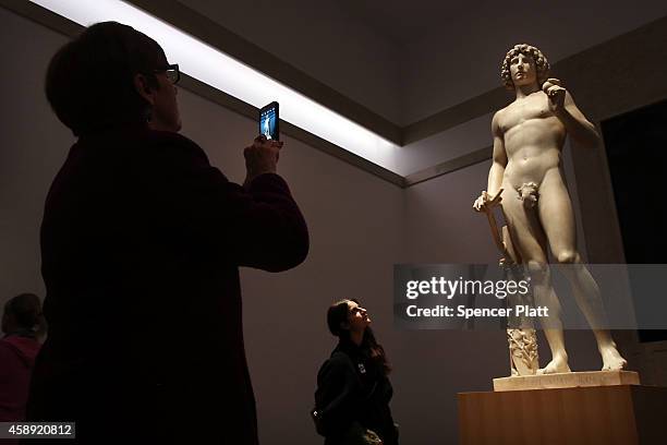 Visitor takes a photo of the marble statue named Adam, created in the 1490s by Italian Renaissance artist Tullio Lombardo, at the Metropolitan Museum...