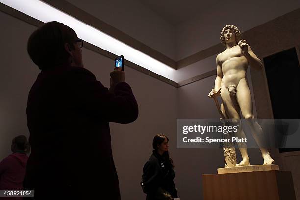 Visitor takes a photo of the marble statue named Adam, created in the 1490s by Italian Renaissance artist Tullio Lombardo, at the Metropolitan Museum...