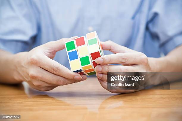 hands playing a cube game - puzzle cube stock pictures, royalty-free photos & images