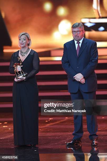 Sabine Kehm, managerin of Michael Schumacher, accepts the award on behalf of Michael Schumacher next to Formula 1 personality Ross Brawn during the...