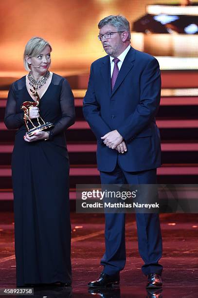 Sabine Kehm, managerin of Michael Schumacher, accepts the award on behalf of Michael Schumacher next to Formula 1 personality Ross Brawn during the...