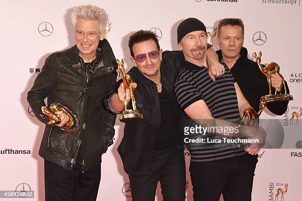 The members of the band U2, Adam Clayton, Bono, The Edge and Larry Mullen junior, pose with their award during Kryolan at the Bambi Awards 2014 on...