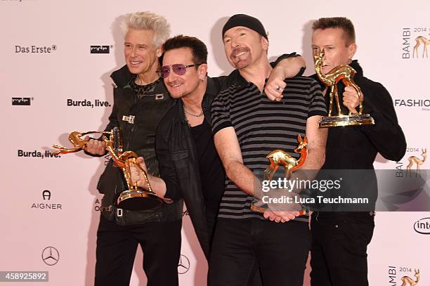 The members of the band U2, Adam Clayton, Bono, The Edge and Larry Mullen junior, pose with their award during Kryolan at the Bambi Awards 2014 on...