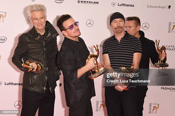 The members of the band U2, Adam Clayton, Bono, The Edge and Larry Mullen junior, pose with their award during Kryolan at the Bambi Awards 2014 on...