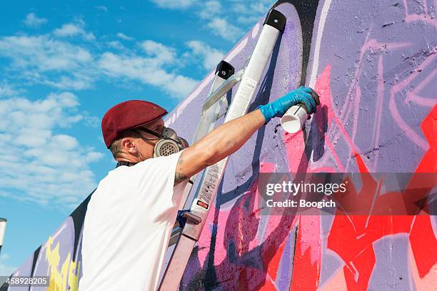masked graffit artist paints wall - 2012 stock pictures, royalty-free photos & images
