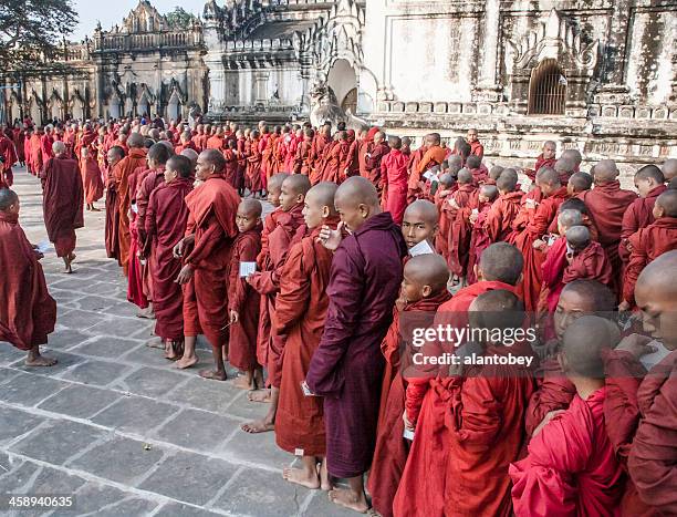 myanmar: line of monks at bagan new year's festival - theravada stock pictures, royalty-free photos & images