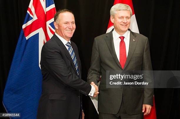 Prime Minister of Canada Stephen Harper shakes hands with Prime Minister of New Zealand John Key after arriving in Auckland on November 14, 2014 at...