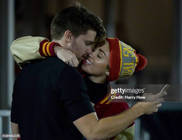 Miley Cyrus kisses Patrick Schwarzenegger during the game between the California Golden Bears and the USC Trojans at Los Angeles Memorial Coliseum on...