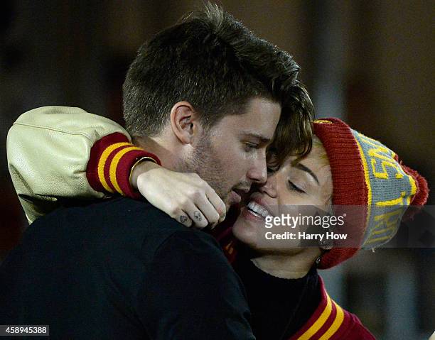 Miley Cyrus kisses Patrick Schwarzenegger during the game between the California Golden Bears and the USC Trojans at Los Angeles Memorial Coliseum on...