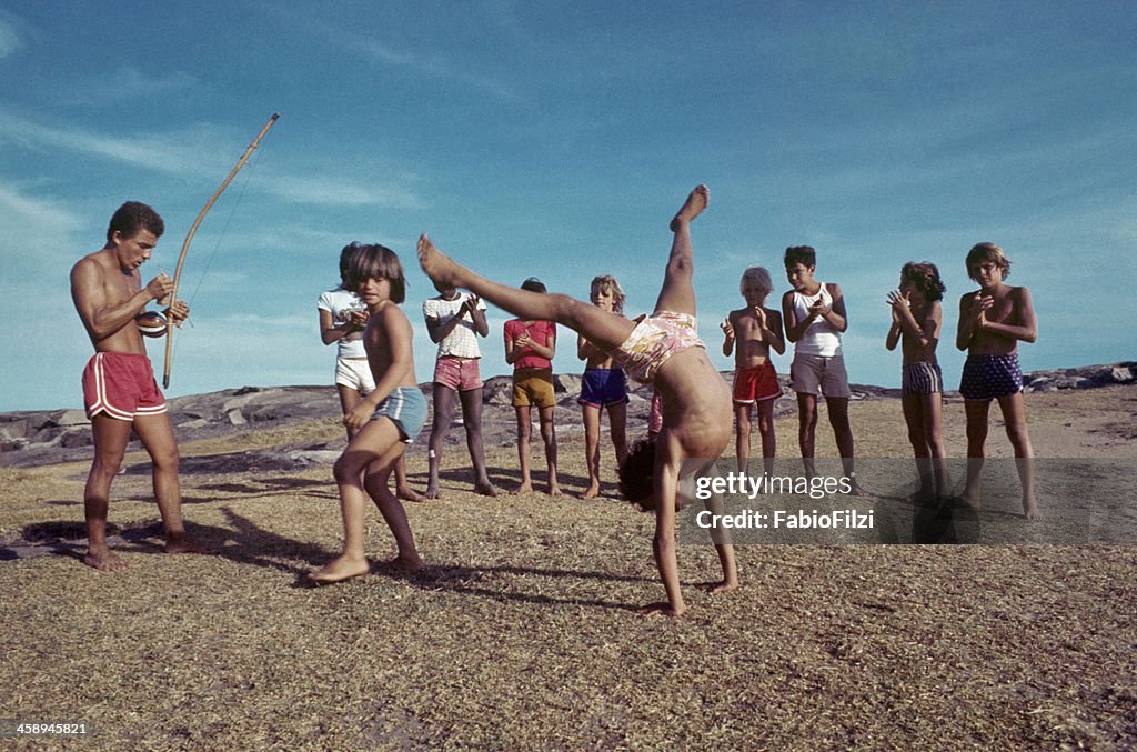 Bambini con insegnante, in pratica la capoeira.