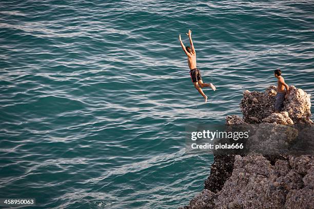 boys diving from nerja cliffs - cliff jumping stock pictures, royalty-free photos & images