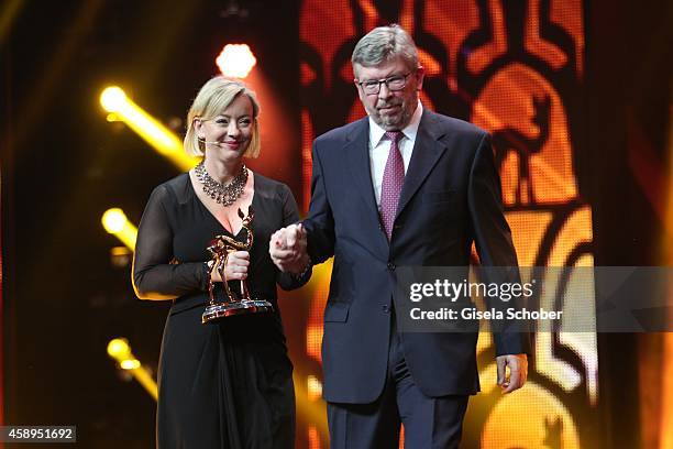 Sabine Kehm and Ross Brawn accept the millennium award on behalf of Michael Schumacher during the Bambi Awards 2014 show on November 13, 2014 in...