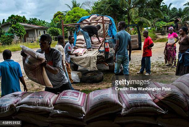 Staff from Orphan Aid, Liberia unload a truck of food and supplies for families affected by Ebola on Friday November 5, 2014 in Dolo's Town, Liberia....
