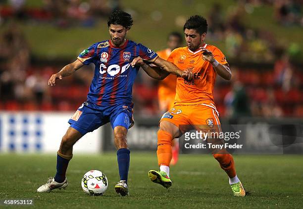 Zenon Caravella of the Jets contests the ball with Dimitri Petratos of the Roar during the round six A-League match between the Newcastle Jets and...