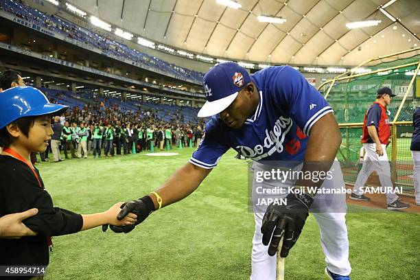 Yasiel Puig of the Los Angeles Dodgers shakes hands with a Japanese fan before the game two of Samurai Japan and MLB All Stars at Tokyo Dome on...
