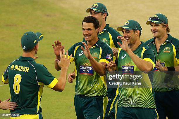 Nathan Coulter-Nile and Mitchell Marsh of Australia celebrate after the dismissal of David Miller of South Africa during game one of the men's one...