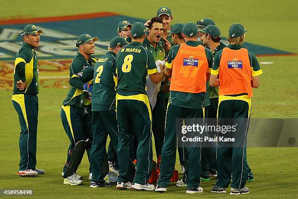 Nathan Coulter-Nile of Australia reacts with team mates after the DRS replay is shown on the big screen for the dismissal of Ryan McLaren of South...