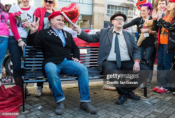 Fans Mark Adams and Lawrence Harman pose on the memorial bench for the late Rik Mayall is unveiled on November 14, 2014 in London, England.