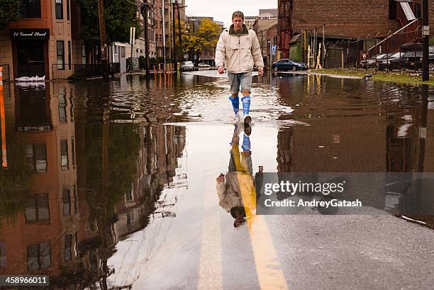 man walking on the flooded street after hurricane sandy landfall - hoboken stockfoto's en -beelden